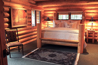 A cozy cabin bedroom illuminated with soft yellow light shows off the latest upgrades