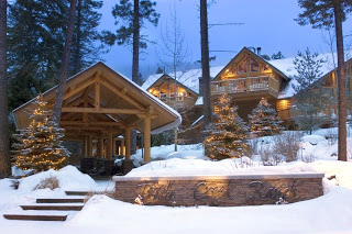 Exterior view of the Triple Creek Ranch cabins at twilight with snow on the ground