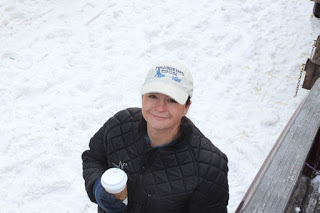 Jessie smiling with a coffee cup in her hands with snow on the ground