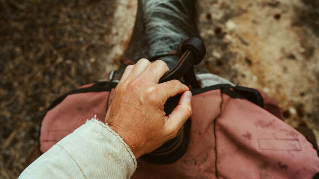 Hand on saddle horn with saddle bags on Horse ride at Triple Creek Ranch