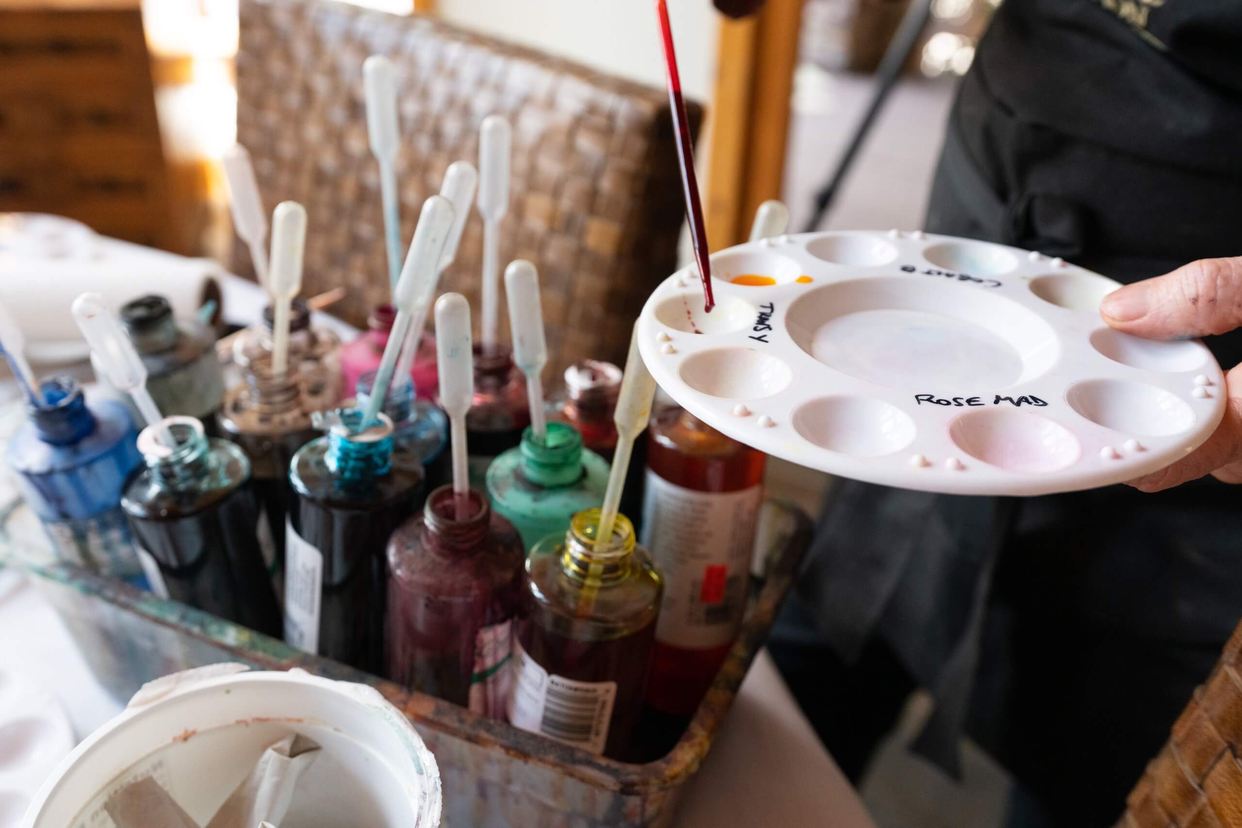 Artist adding paint to her palette.