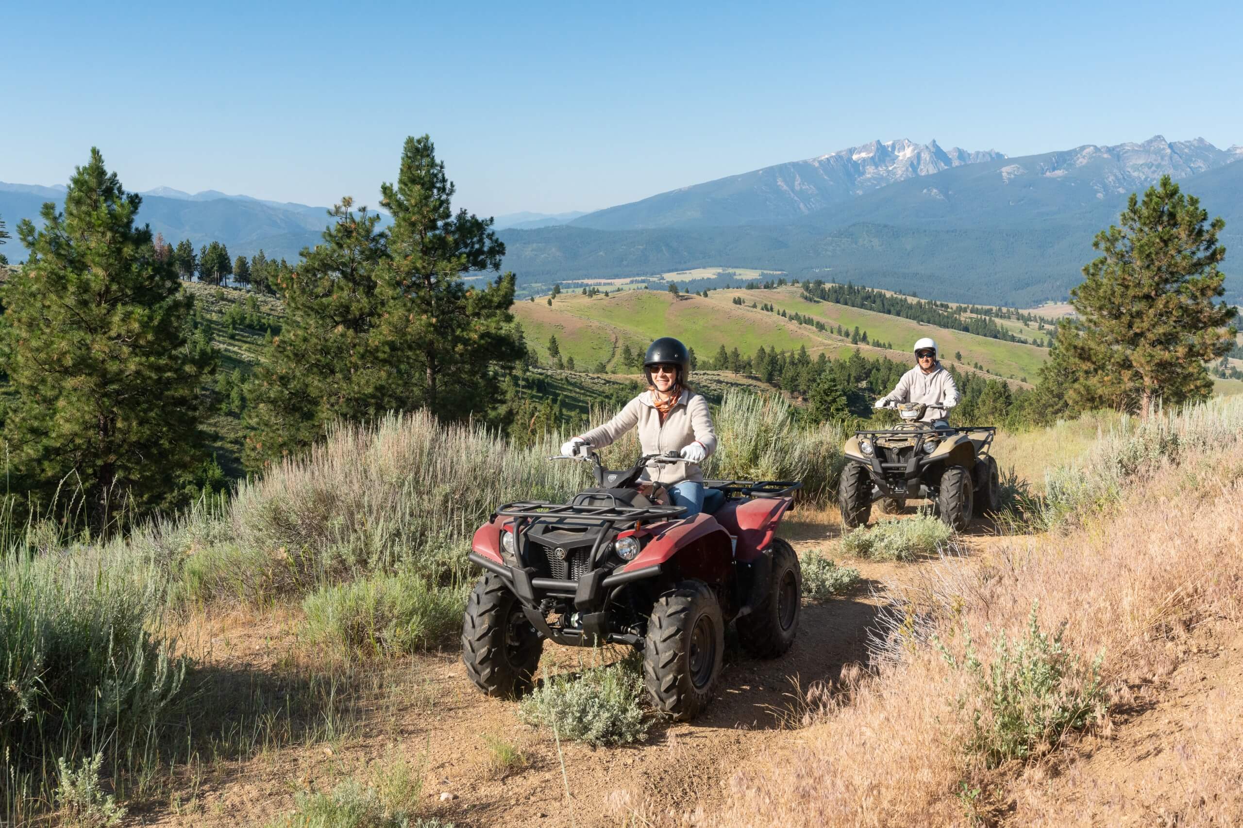 Guests riding ATVs across a mountain landscape