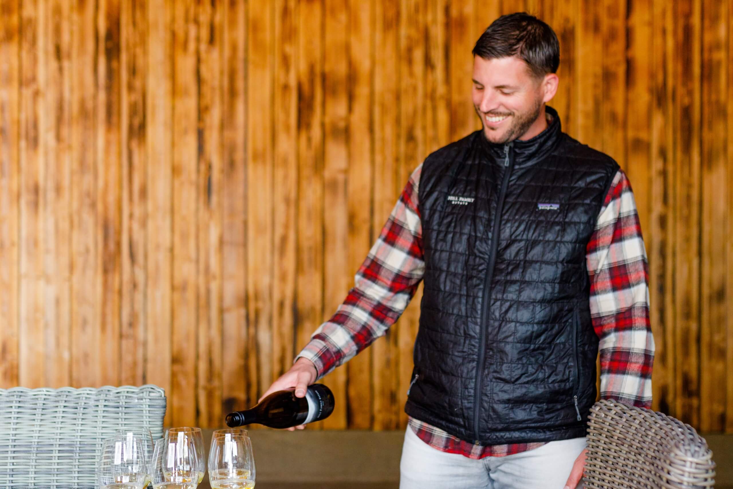 Ryan Hill pouring wine into a wine glass.