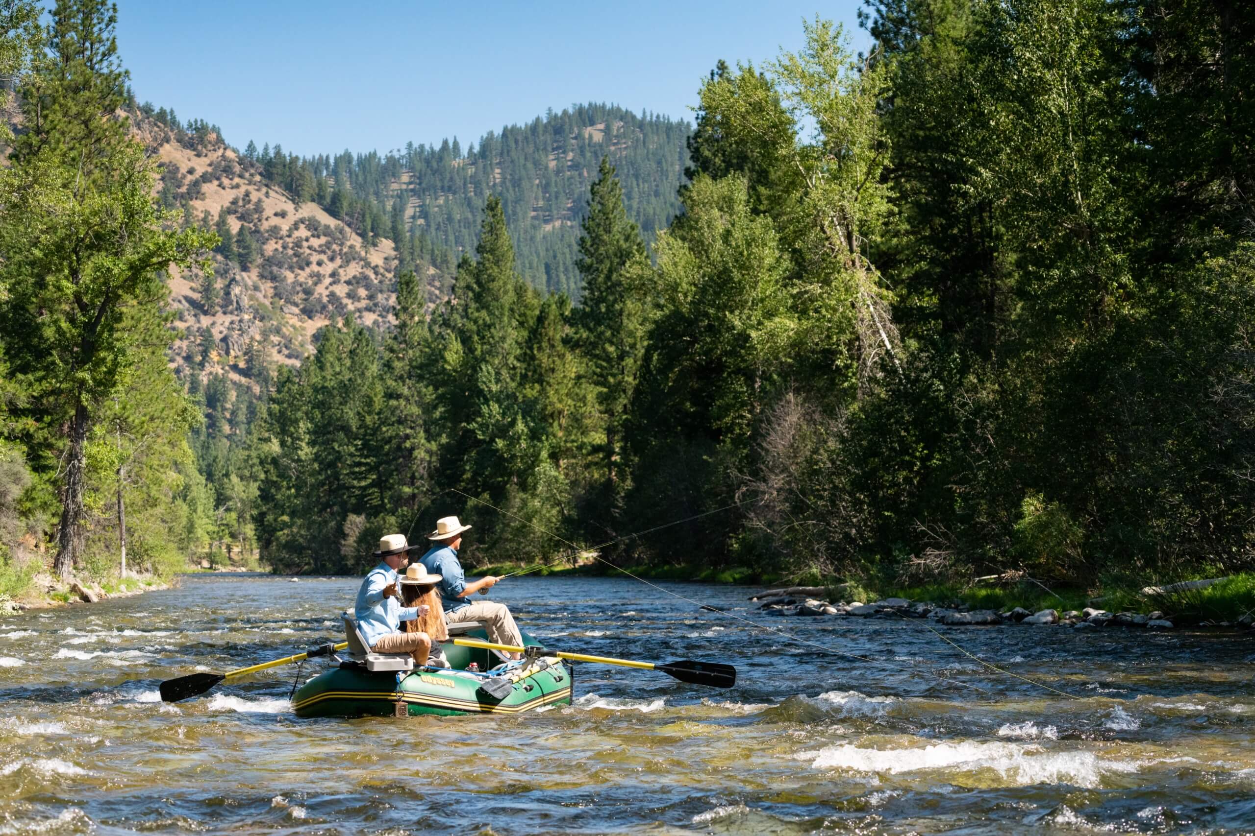 Guests Fly Fishing on the west fork river with the bitterroot mountains in the background.
