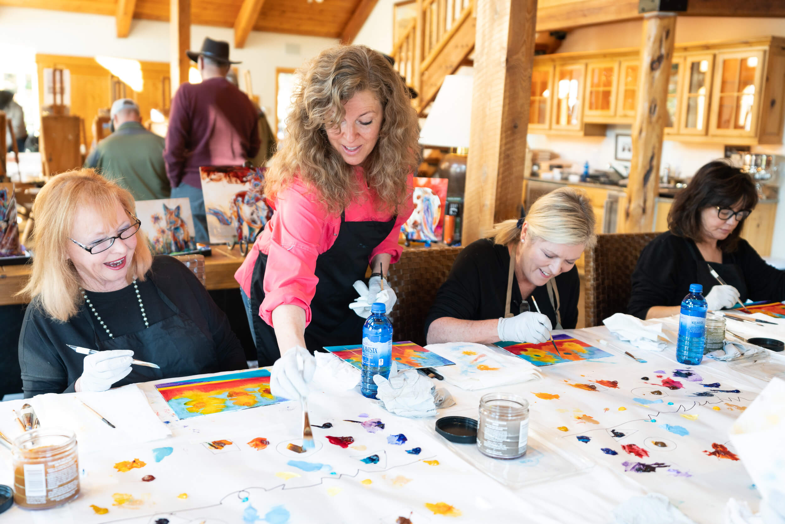 Artist Carol Hagan teaching a guest how to paint.