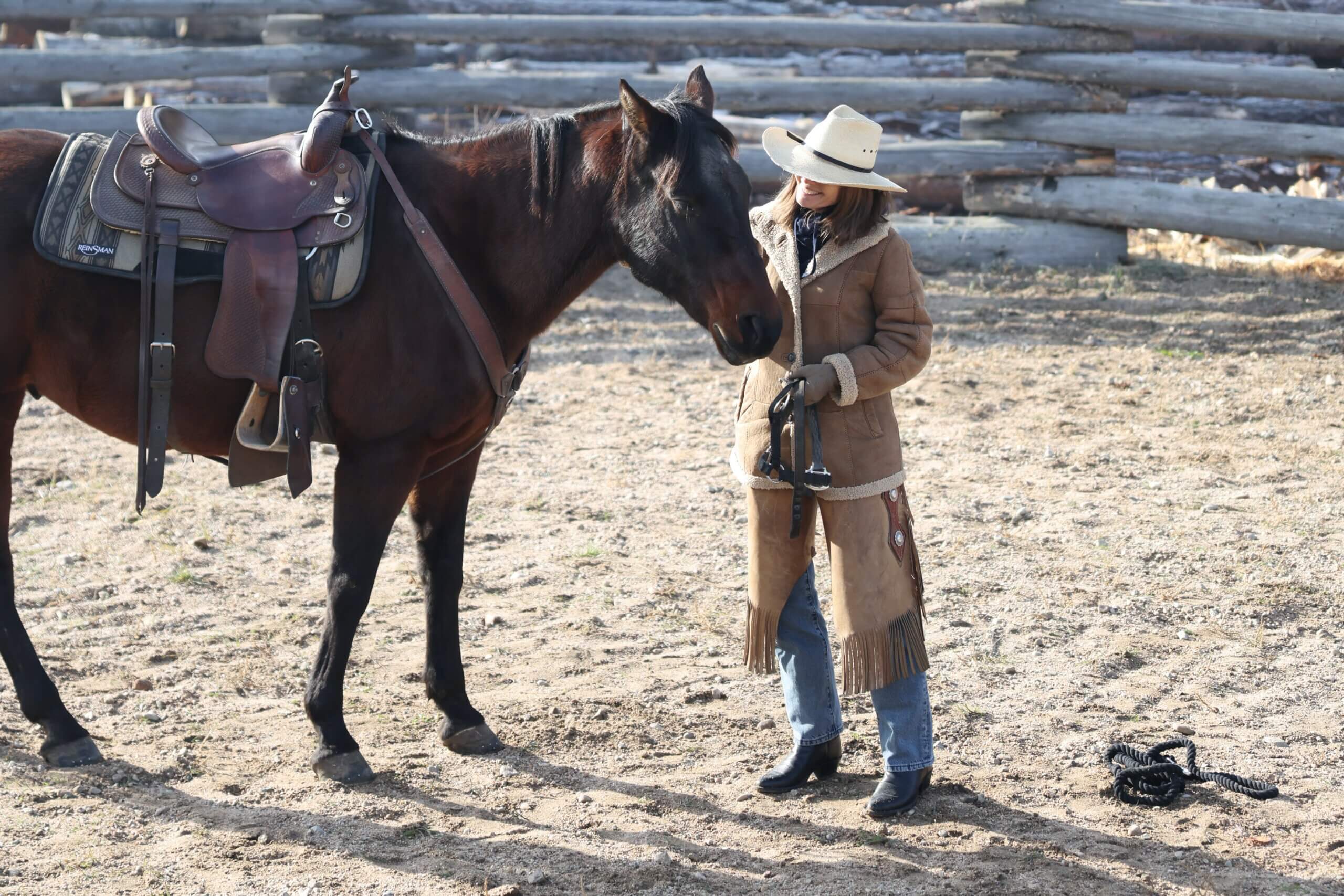 Triple Creek Ranch Guest engaging in Horsemanship Join Up activity with horse in an arena for the annual Cowboy School Event